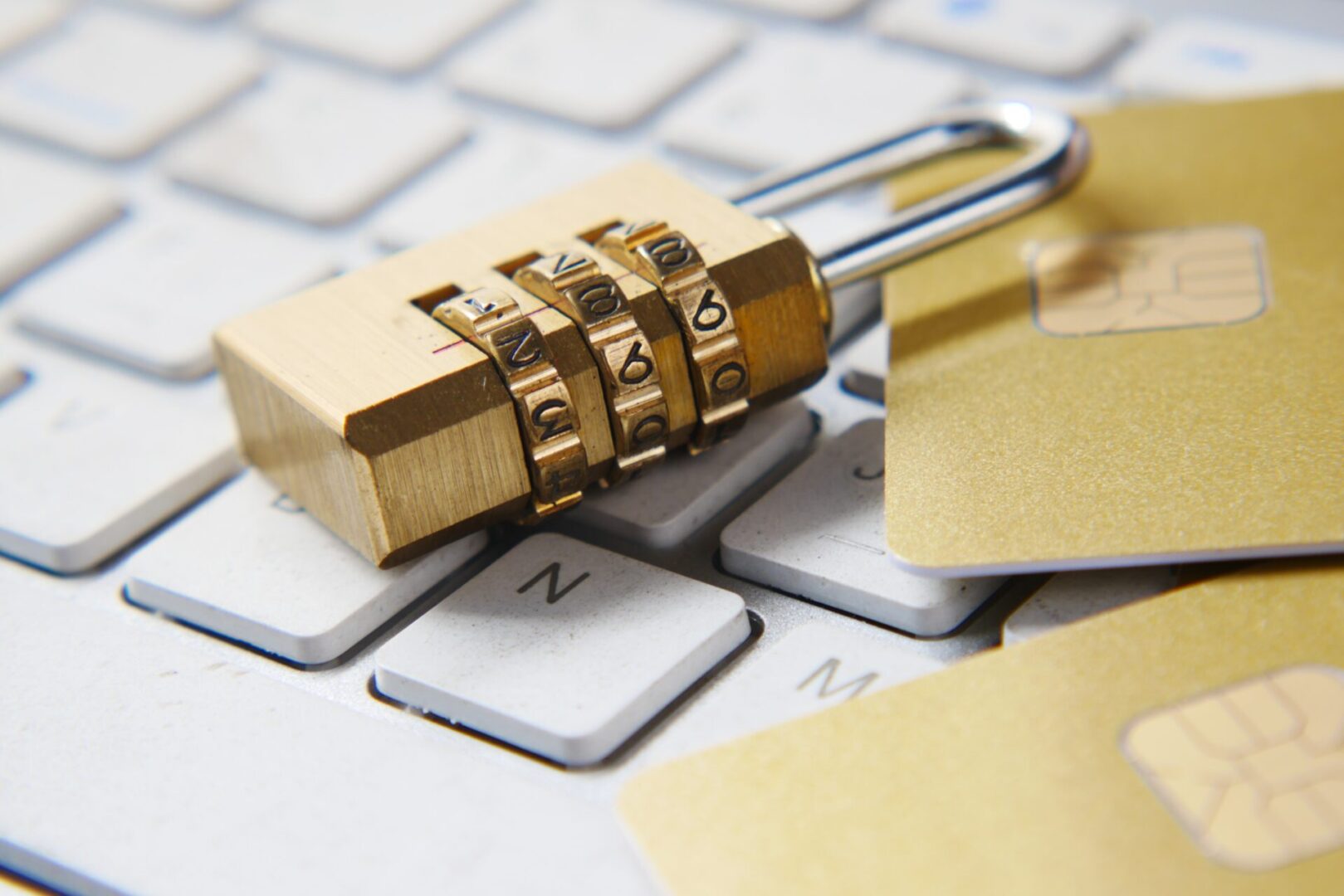 A padlock on top of a keyboard with cards.